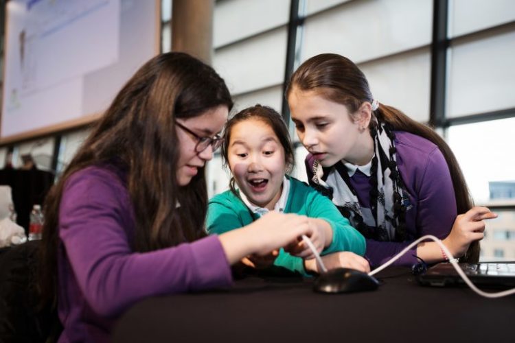 Three young female students doing a science experiment