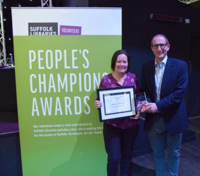 A picture of Mandy Grimwood, manager of Gainsborough Community Library, holding an award next to a colleague. She's holding an award for the People's Champion Award